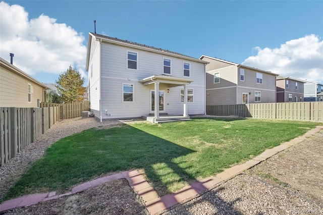 rear view of house featuring a lawn and central air condition unit