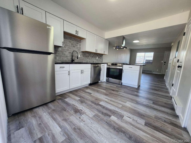 25 Castle Royal Dr, Pueblo, CO 81005 - kitchen with appliances with stainless steel finishes, wall chimney exhaust hood, a sink, and dark countertops