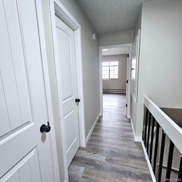 25 Castle Royal Dr, Pueblo, CO 81005 - hallway with a textured ceiling, wood finished floors, a baseboard radiator, and baseboards