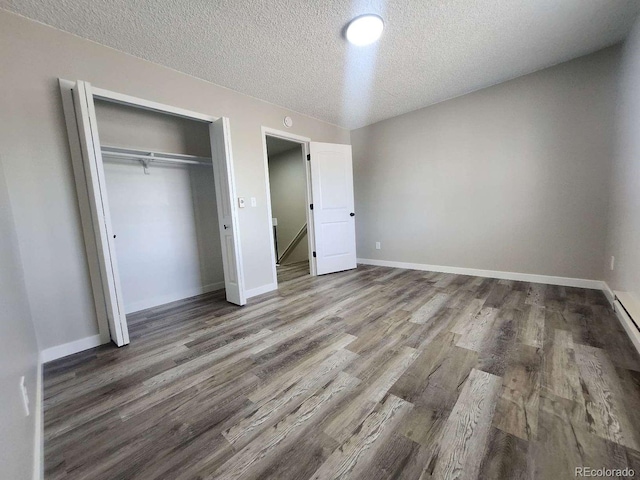 25 Castle Royal Dr, Pueblo, CO 81005 - unfurnished bedroom with wood finished floors, a textured ceiling, a closet, and baseboards