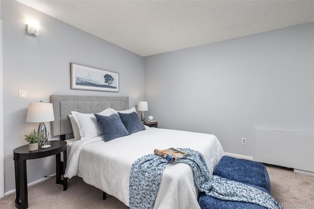 carpeted bedroom featuring a textured ceiling and baseboards