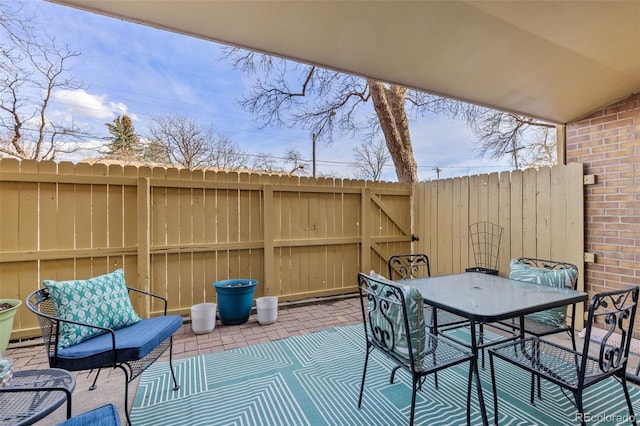 view of patio with outdoor dining space and fence