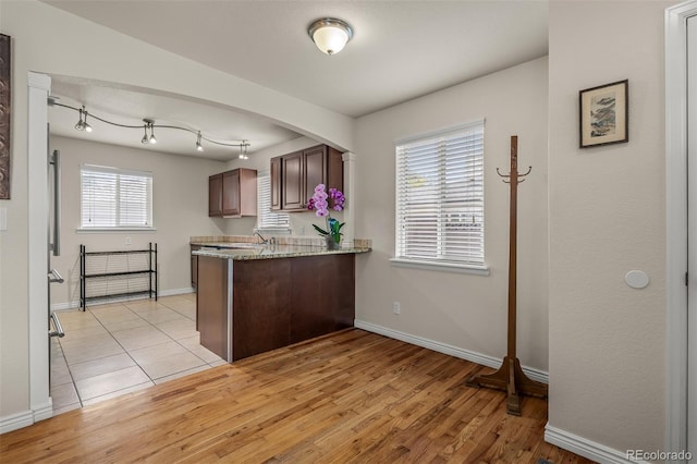 2907 Pennsylvania Ave, Colorado Springs, CO 80907 - kitchen featuring a peninsula, baseboards, light wood-style floors, and light stone countertops