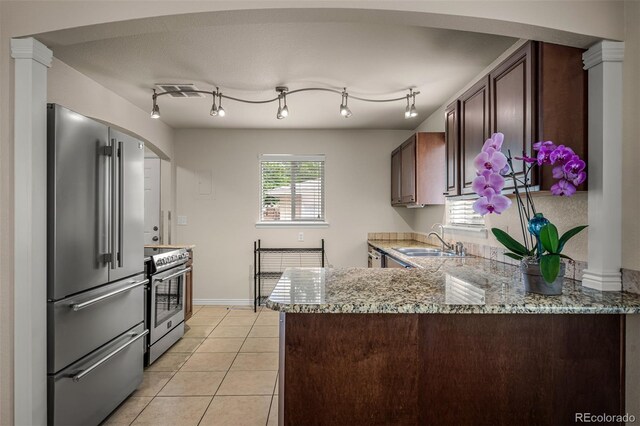 2907 Pennsylvania Ave, Colorado Springs, CO 80907 - kitchen with stainless steel appliances, a sink, a peninsula, and dark brown cabinets