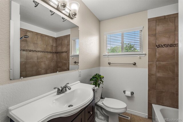 2907 Pennsylvania Ave, Colorado Springs, CO 80907 - bathroom with vanity, toilet, a textured wall, tub / shower combination, and tile patterned floors