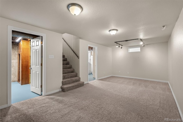 2907 Pennsylvania Ave, Colorado Springs, CO 80907 - finished below grade area featuring rail lighting, carpet floors, stairs, baseboards, and a textured ceiling