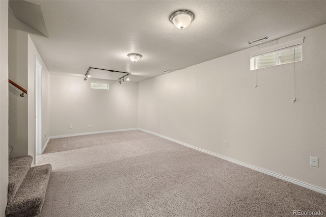2907 Pennsylvania Ave, Colorado Springs, CO 80907 - basement featuring track lighting, stairway, carpet floors, and a textured ceiling