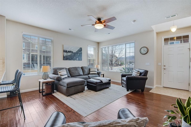living room with ceiling fan, hardwood / wood-style flooring, baseboards, and visible vents