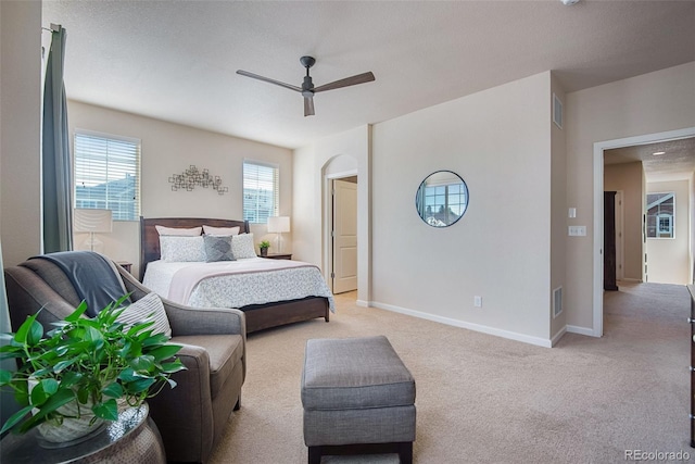 bedroom with ceiling fan, light carpet, baseboards, and visible vents
