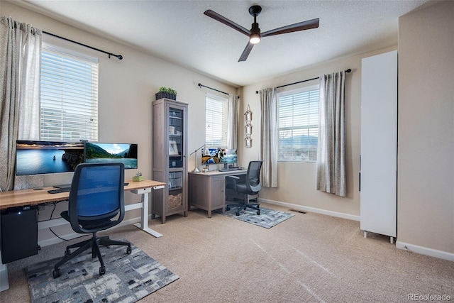 home office featuring light colored carpet, visible vents, baseboards, and a ceiling fan