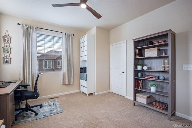 office area with baseboards, visible vents, ceiling fan, and carpet floors