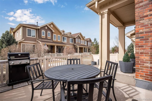 view of patio / terrace featuring a grill, outdoor dining area, and a residential view