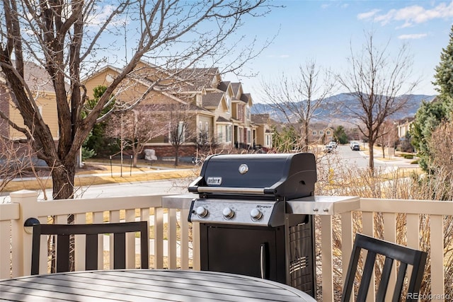 wooden terrace featuring grilling area, a mountain view, and a residential view
