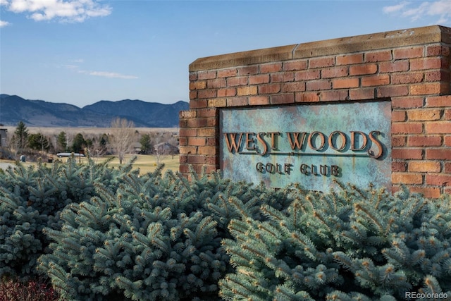 community / neighborhood sign with a mountain view