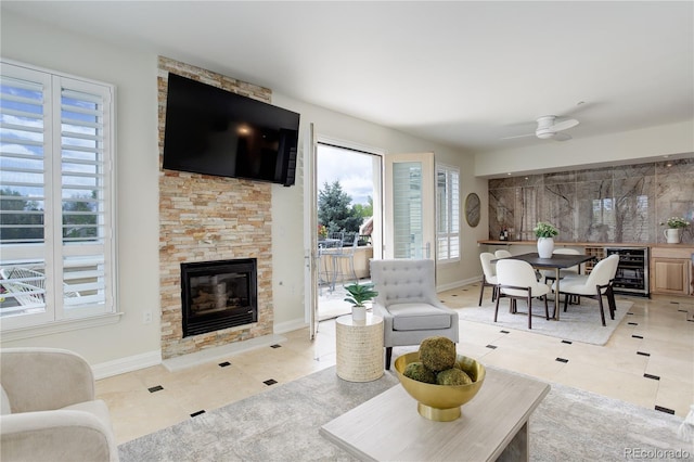 2500 E Cherry Creek S Drive 306, Denver, CO 80209 - living area with beverage cooler, a stone fireplace, tile patterned flooring, baseboards, and ceiling fan