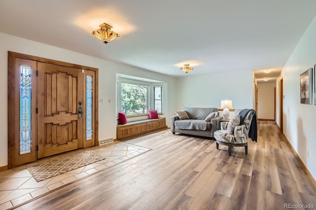 entryway featuring baseboards, visible vents, and light wood-type flooring