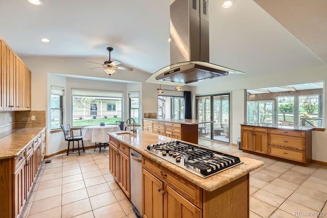 kitchen featuring stainless steel gas stovetop, light tile patterned floors, island range hood, vaulted ceiling, and a center island with sink