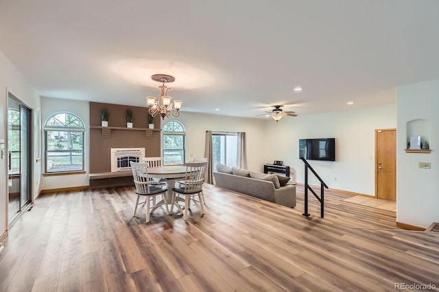 dining space with a fireplace, recessed lighting, plenty of natural light, and wood finished floors