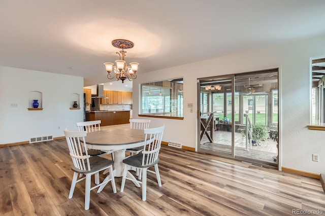 dining area with an inviting chandelier, visible vents, and baseboards
