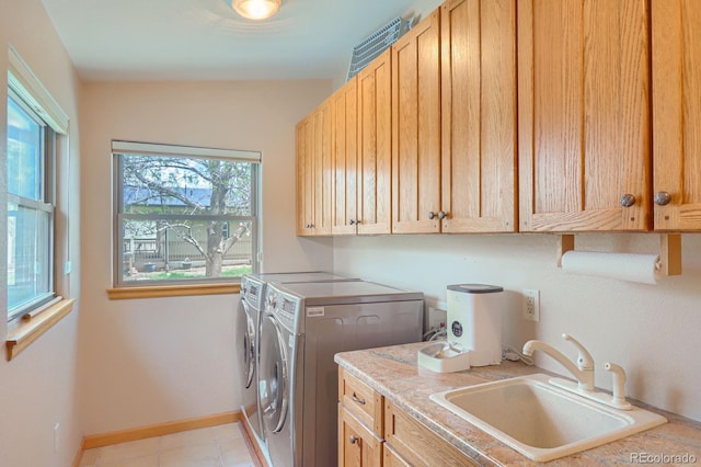 washroom with baseboards, a sink, cabinet space, and washer and clothes dryer