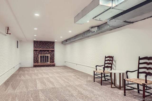 living area with brick wall, a brick fireplace, carpet, and recessed lighting