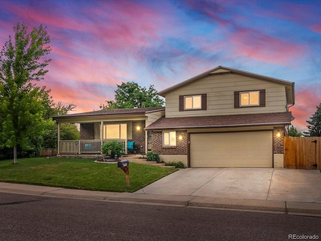 6166 S Dover St, Littleton, CO 80123 - split level home featuring covered porch, brick siding, concrete driveway, an attached garage, and a shingled roof
