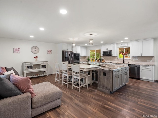 6166 S Dover St, Littleton, CO 80123 - kitchen with stainless steel appliances, a kitchen island, backsplash, white cabinets, and recessed lighting
