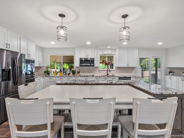 6166 S Dover St, Littleton, CO 80123 - kitchen with stainless steel appliances, backsplash, plenty of natural light, white cabinetry, and recessed lighting