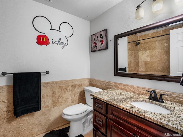 6166 S Dover St, Littleton, CO 80123 - bathroom featuring vanity, a tile shower, wainscoting, and tile walls