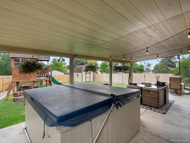 6166 S Dover St, Littleton, CO 80123 - fenced backyard featuring a hot tub, a playground, a storage shed, and a patio