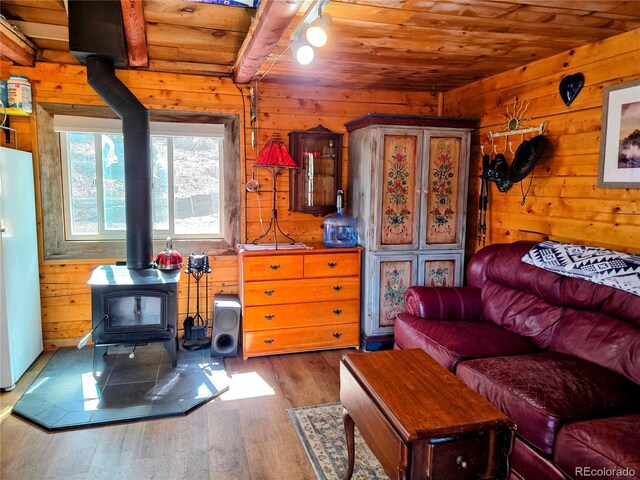163 Ward St, Bailey, CO 80421 - living area featuring a wood stove, wood finished floors, wood walls, and wooden ceiling