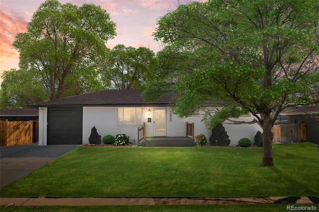 ranch-style house with a garage and a yard