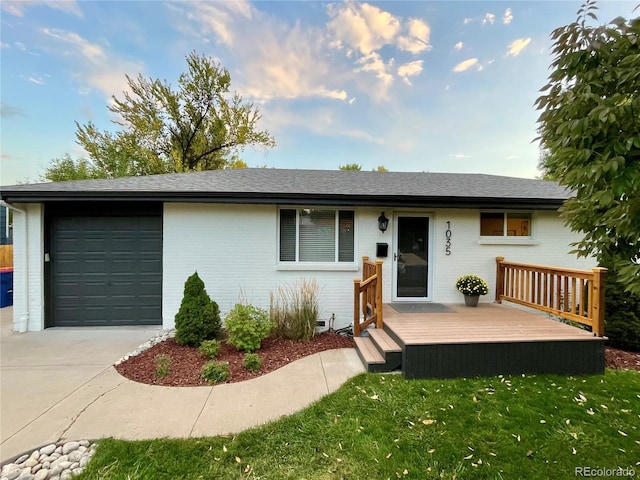 ranch-style home with a garage, a deck, and a front lawn