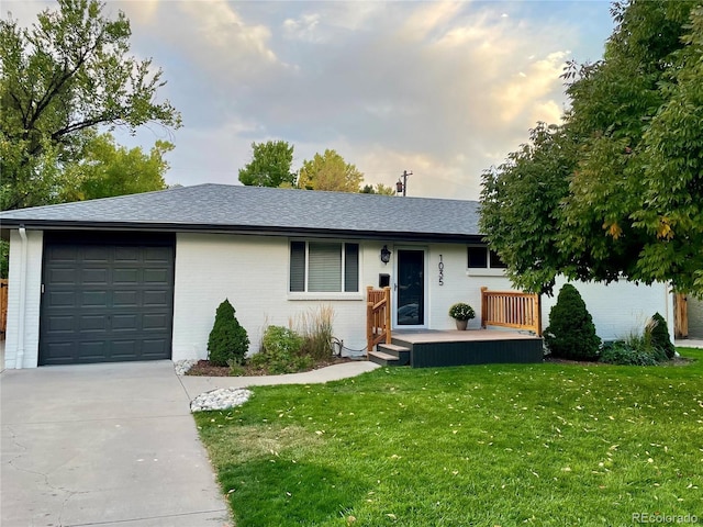 single story home with a garage, a lawn, and covered porch