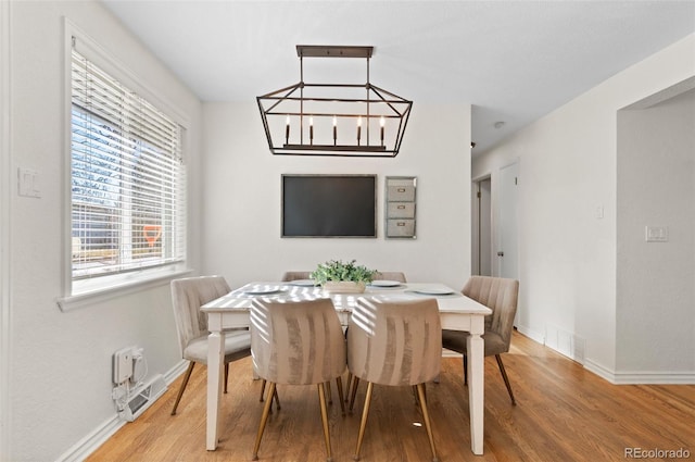 dining space featuring a notable chandelier and wood-type flooring