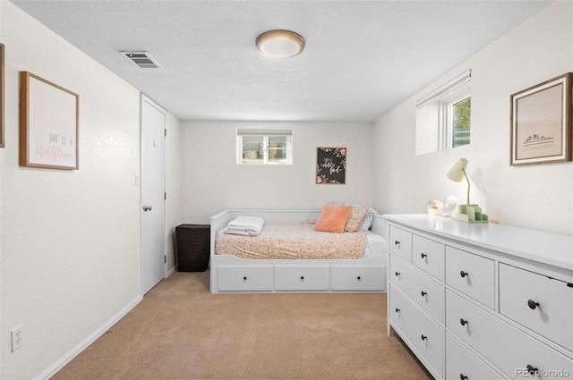 carpeted bedroom featuring multiple windows and a textured ceiling