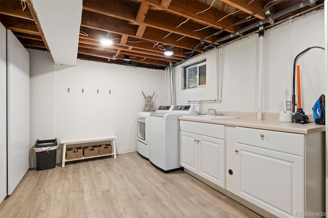 washroom with cabinets, sink, light hardwood / wood-style flooring, and independent washer and dryer