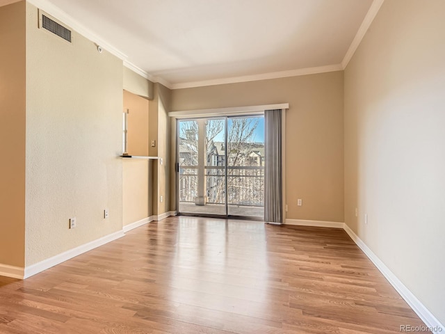 empty room with light wood-type flooring and ornamental molding