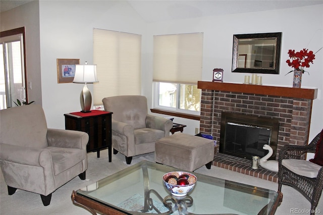 carpeted living room with lofted ceiling and a brick fireplace