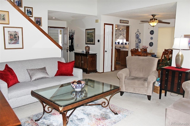 carpeted living area featuring ceiling fan