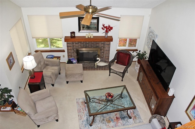 carpeted living room featuring ceiling fan and a brick fireplace