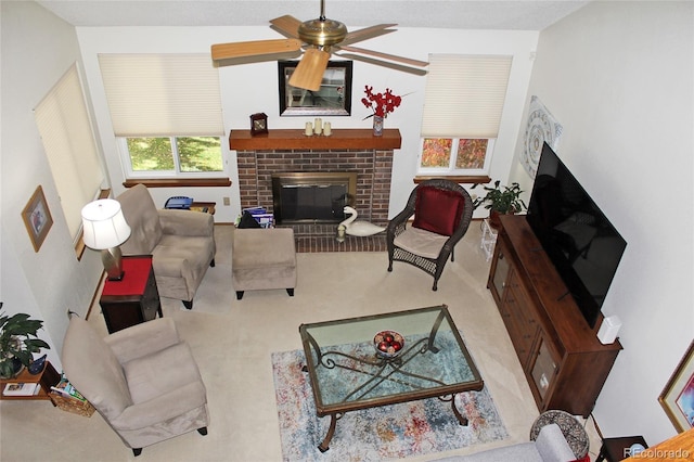 carpeted living area featuring a ceiling fan and a brick fireplace