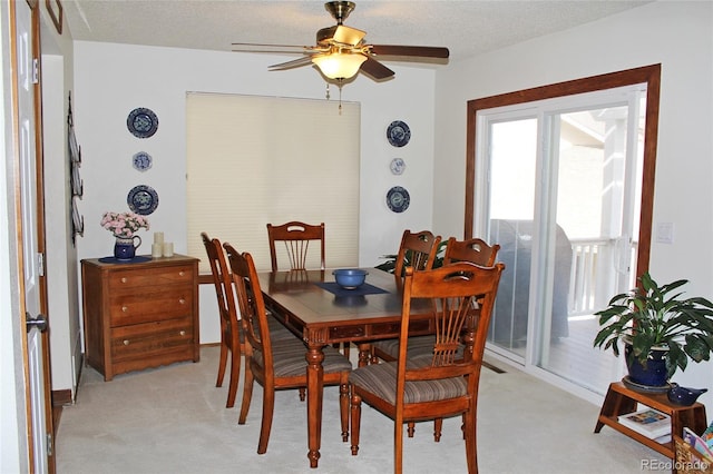 dining room with ceiling fan, a textured ceiling, and light colored carpet