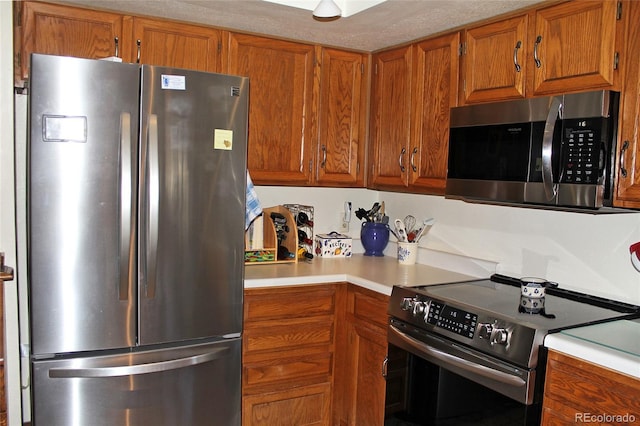 kitchen with light countertops, appliances with stainless steel finishes, and brown cabinets