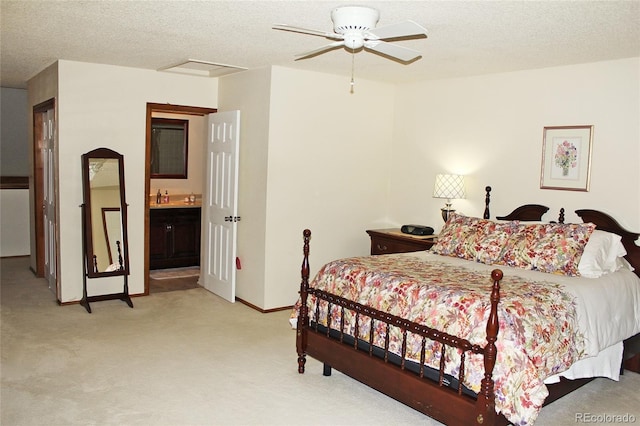 bedroom with light carpet, a textured ceiling, connected bathroom, and ceiling fan