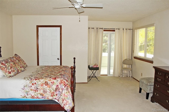 bedroom featuring ceiling fan, a textured ceiling, and light colored carpet