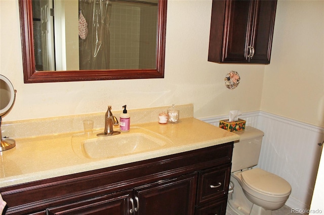 full bath featuring a wainscoted wall, toilet, vanity, and a shower with curtain