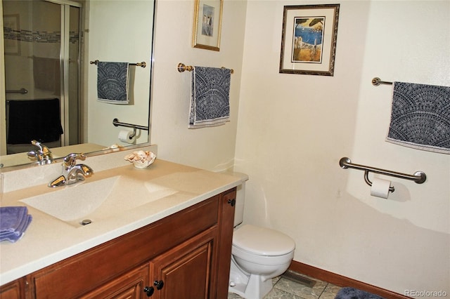 bathroom with a shower with door, vanity, toilet, and tile patterned floors