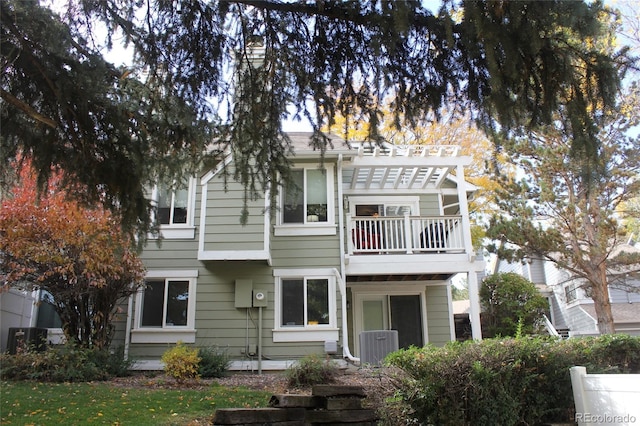 view of front of house with central air condition unit and a balcony