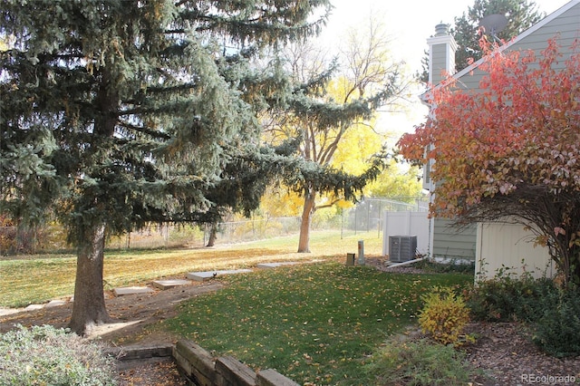 view of yard featuring central AC unit and fence